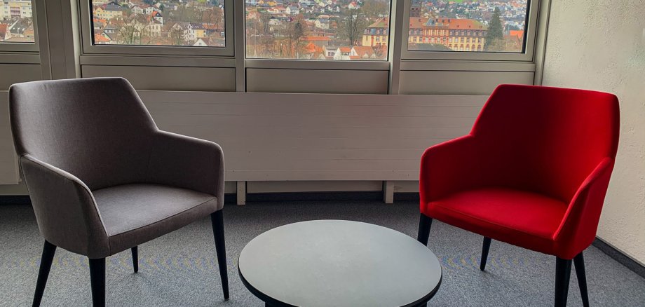 Grauer und roter Sessel mit kleinem Tisch in Raum